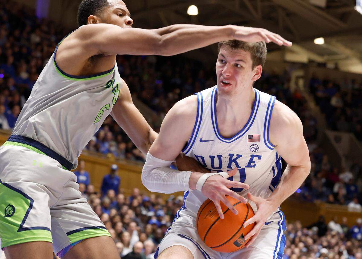 Duke’s Kyle Filipowski (30) keeps the ball from Queens’ BJ McLaurin (6) during the first half of Duke’s game against Queens University at Cameron Indoor Stadium in Durham, N.C., Saturday, Dec. 30, 2023.
