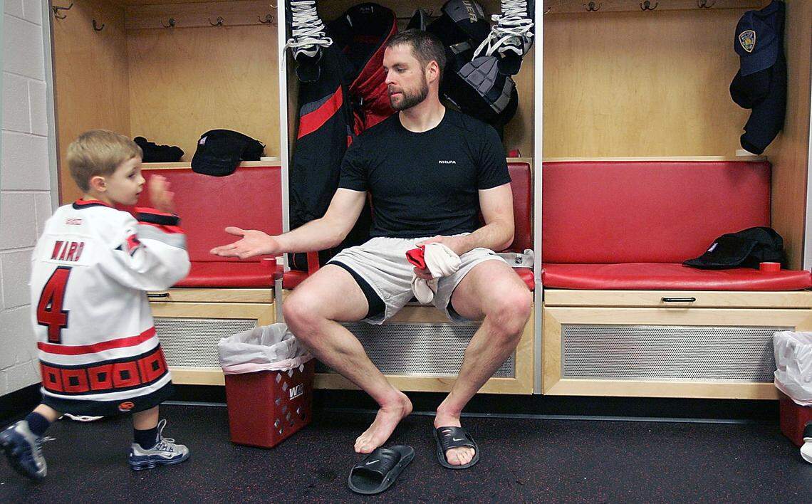 Liam Ward, left, spends time with his father Aaron Ward after a Hurricanes’ team practice Saturday, May 27, 2006, in the RBC Center locker room.