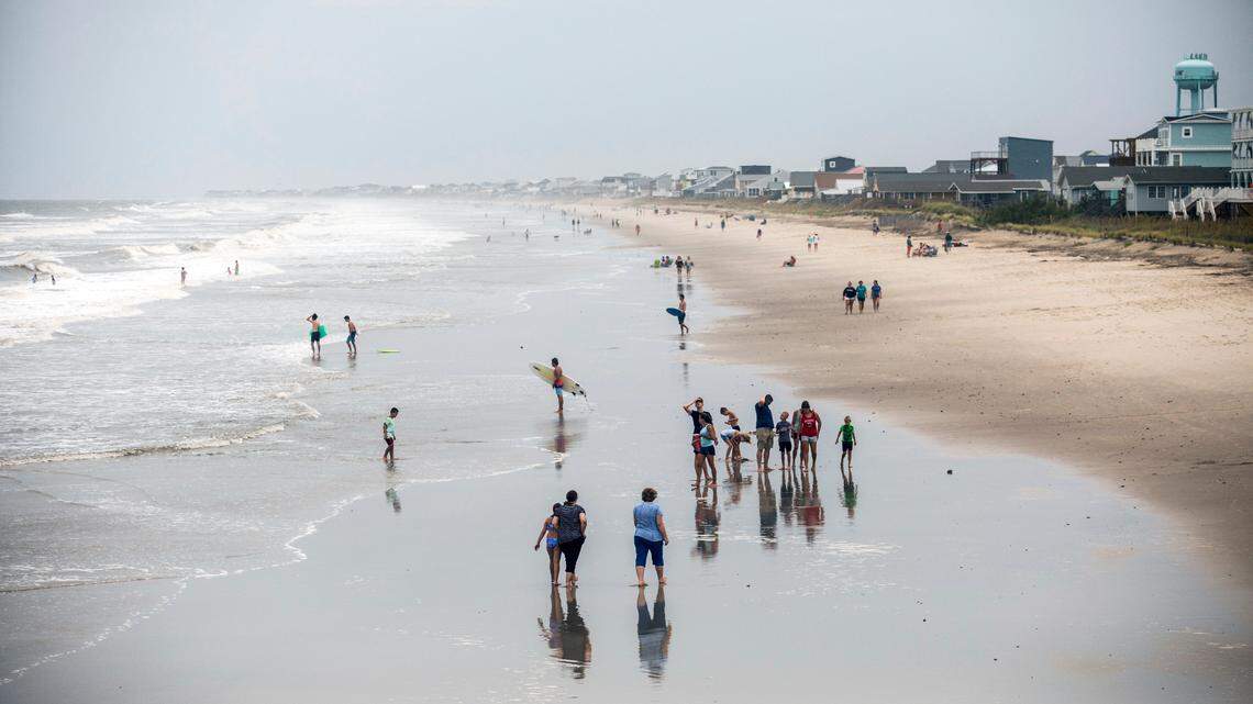 Beachgoers dot Oak Island’s beach Monday, Aug. 3, 2020 as Tropical Storm Isaias moves towards the southeast coast. The storm is expected to strengthen to a hurricane before making landfall.