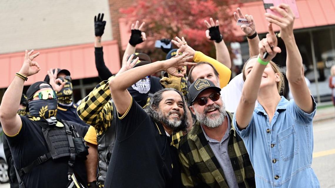 Emily Grace Rainey poses for a selfie with members of the Proud Boys outside a drag show.