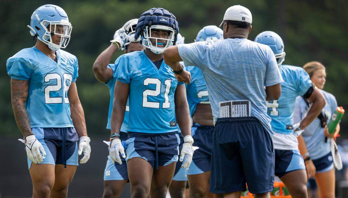 North Carolina running backs coach Larry Porter works with Elijah Green (21) during their first day of practice on Wednesday, August 2, 2023 in Chapel Hill, N.C.