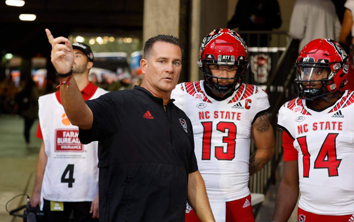 N.C. State offensive coordinator Tim Beck talks with the quarterbacks before they head out onto the field to warm up before N.C. State’s game against Clemson at Memorial Stadium in Clemson, S.C., Saturday, Oct. 1, 2022.