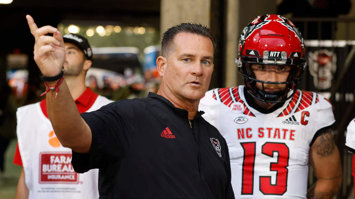 N.C. State offensive coordinator Tim Beck talks with the quarterbacks before they head out onto the field to warm up before N.C. State’s game against Clemson at Memorial Stadium in Clemson, S.C., Saturday, Oct. 1, 2022.