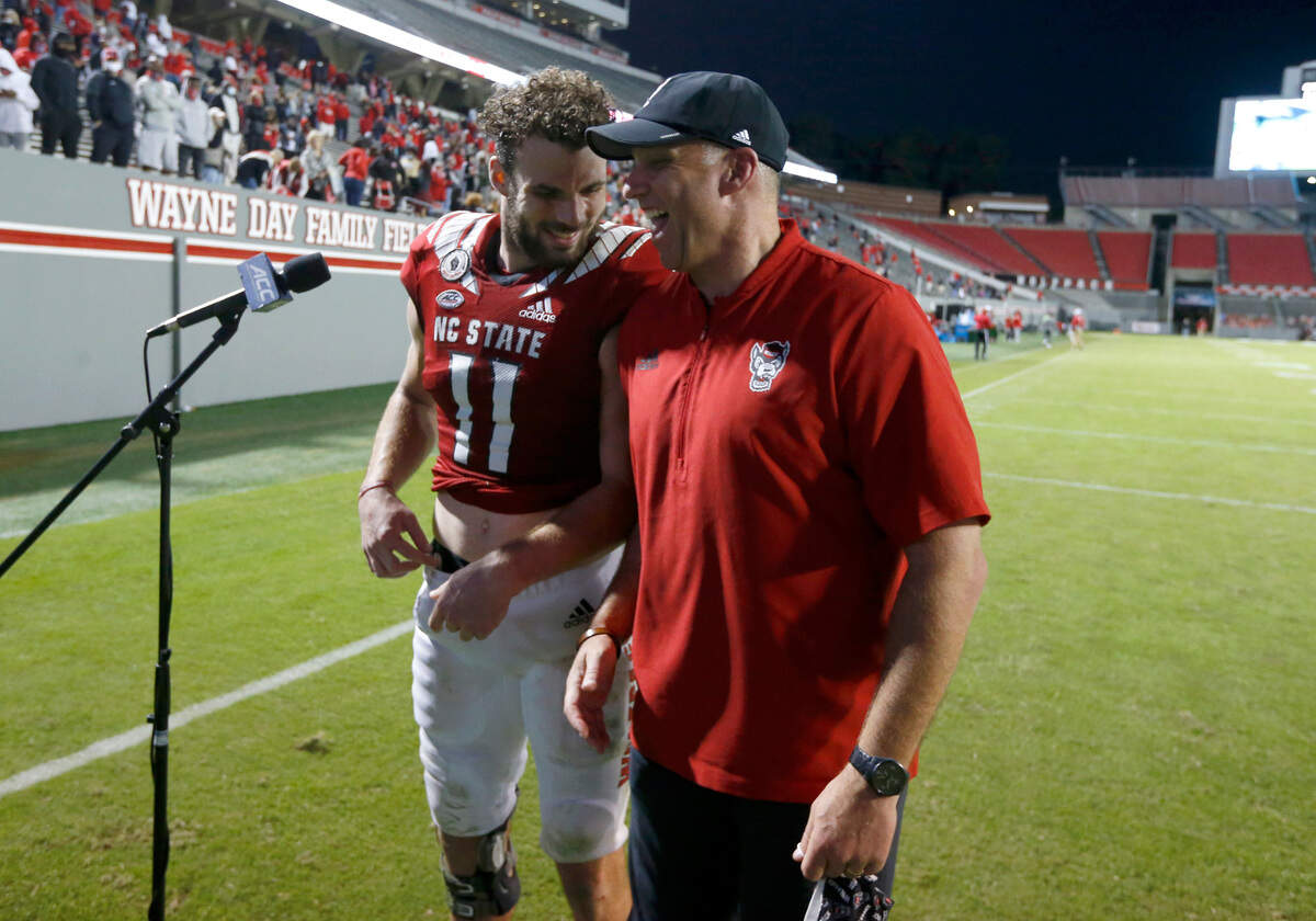 N.C. State head coach Dave Doeren laughs with Payton Wilson (11) after N.C. State’s 31-20 victory over Duke at Carter-Finley Stadium in Raleigh, N.C., Saturday, Oct. 17, 2020.
