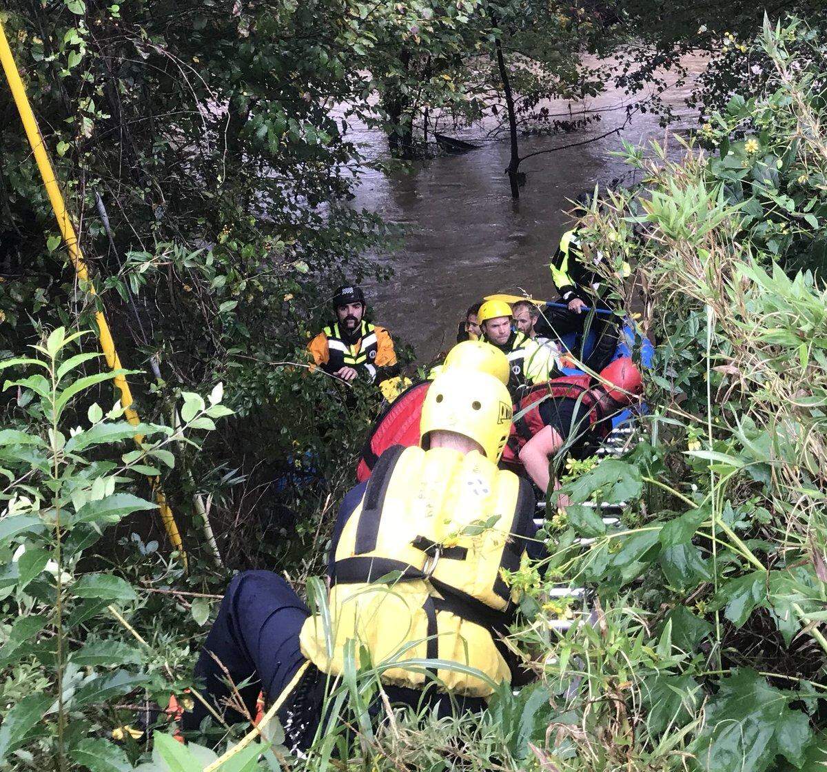 The Asheville Fire Department used a ladder truck and a boat to rescue two people trapped in a hammock over a swollen river during Tropical Storm Michael on Thursday, Oct. 11, 2018.