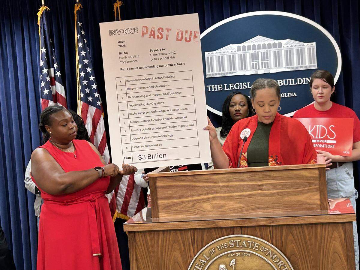 Leaders of the North Carolina Association of Educators hold up an “invoice” for $3 billion that they say corporations owe the state’s public schools during a press conference on April 23, 2026, in the Legislative Building in Raleigh, N.C.
