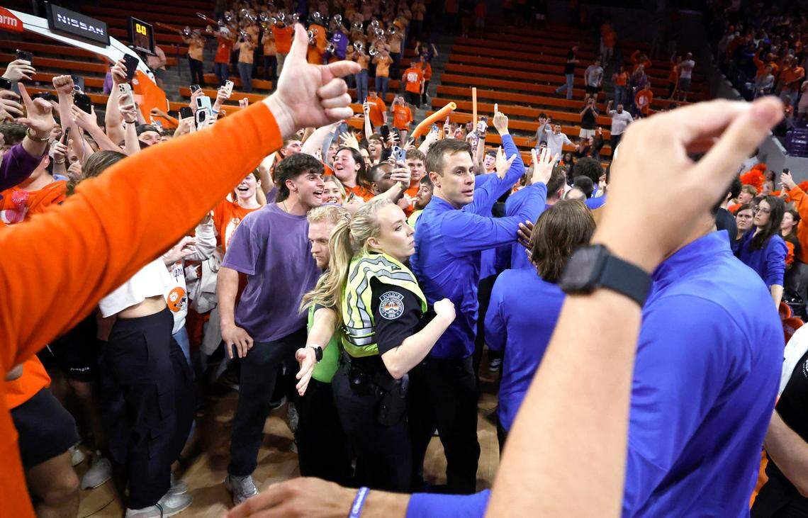 Fans storm the court as Duke staff try to keep them from the players after Clemson’s 77-71 victory over Duke at Littlejohn Coliseum in Clemson, S.C., Saturday, Feb. 8, 2025.