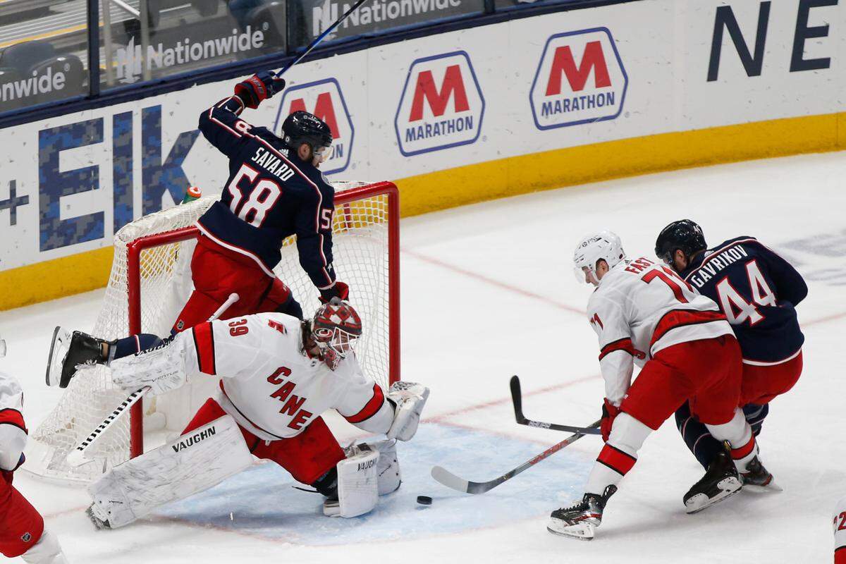 Carolina Hurricanes’ Alex Nedeljkovic, front left, makes a save in front of Columbus Blue Jackets’ David Savard, top, as Blue Jackets’ Vladislav Gavrikov, right, and Hurricanes’ Jesper Fast look for the rebound during the third period of an NHL hockey game Thursday, March 25, 2021, in Columbus, Ohio. The Hurricanes won 4-3 in overtime. (AP Photo/Jay LaPrete)