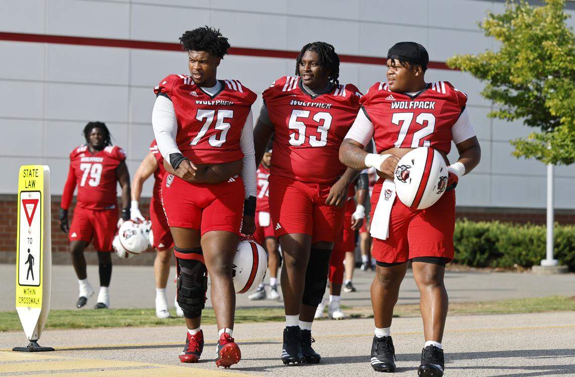 N.C. State’s Anthony Carter (75), Brock Stukes (53) and Spike Sowells (72) head to the Wolfpack’s first fall practice Wednesday, July 30, 2025.