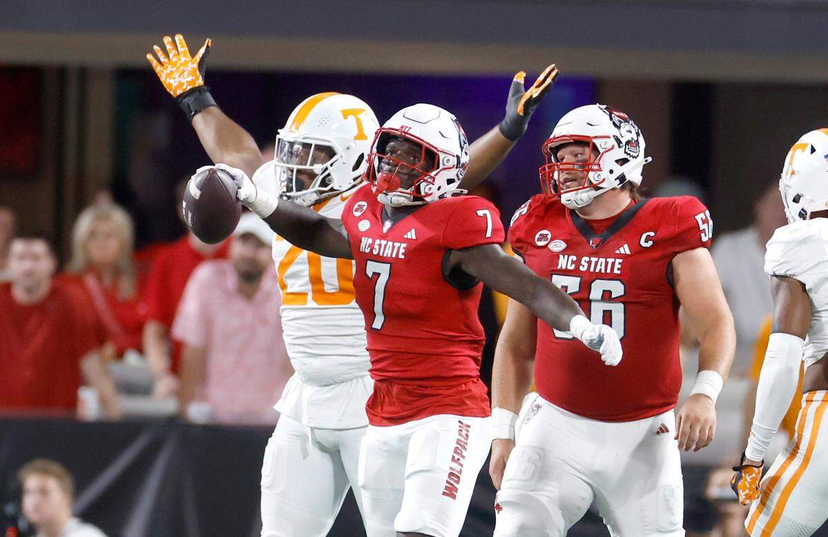N.C. State running back Jordan Waters (7) reacts after being stopped for a loss as Tennessee defensive lineman Bryson Eason (20) celebrates during the first half of N.C. State’s game against Tennessee in the Duke’s Mayo Classic at Bank of America Stadium in Charlotte, N.C., Saturday, Sept. 7, 2024.