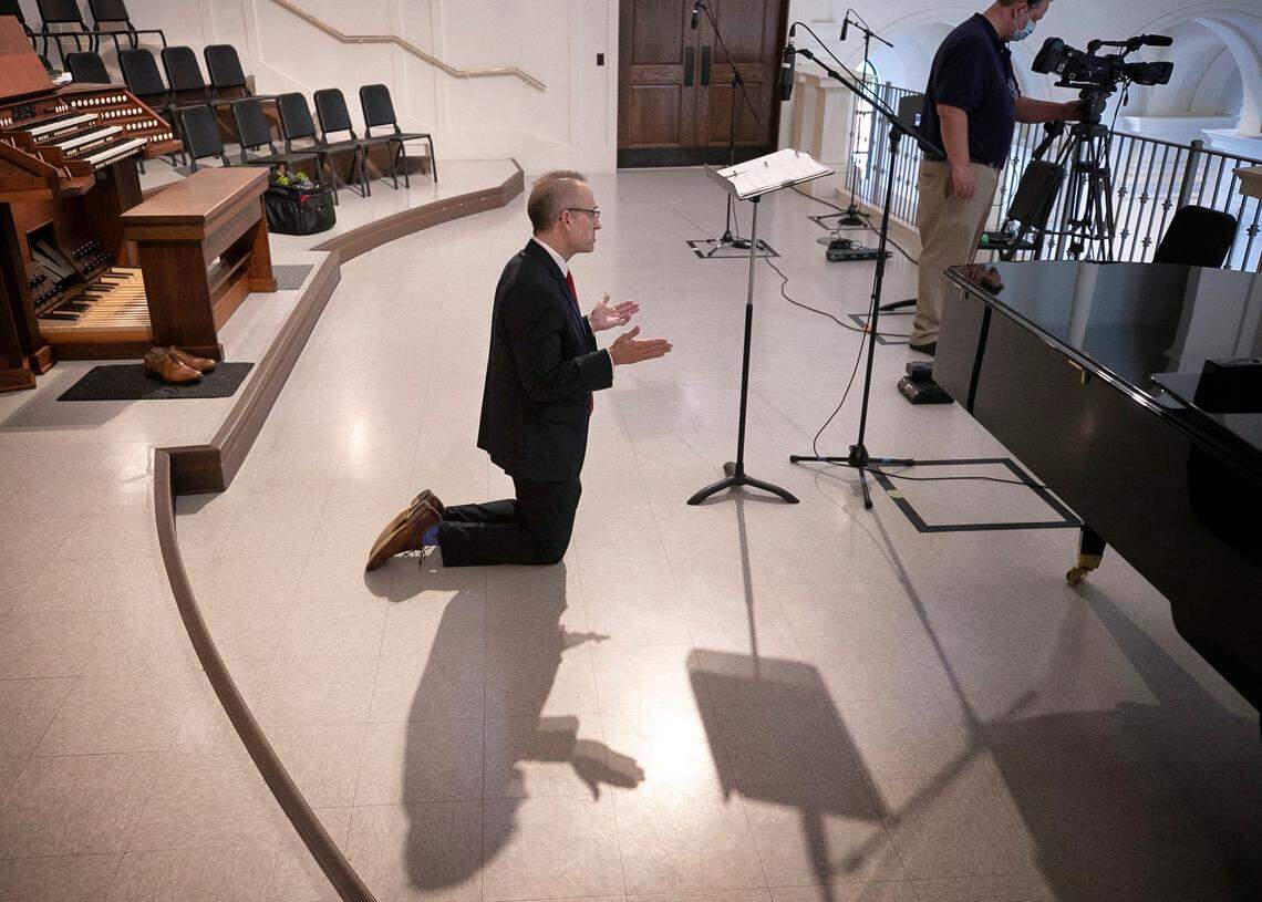 Pierre LaPierre kneels to receive Holy Communion at the Holy Name of Jesus Cathedral during Palm Sunday Mass on Sunday, April 5, 2020 in Raleigh, N.C. LaPierre is a cantor, performing from the balcony in the empty Cathedral and was served communion by Deacon Juan Banda.