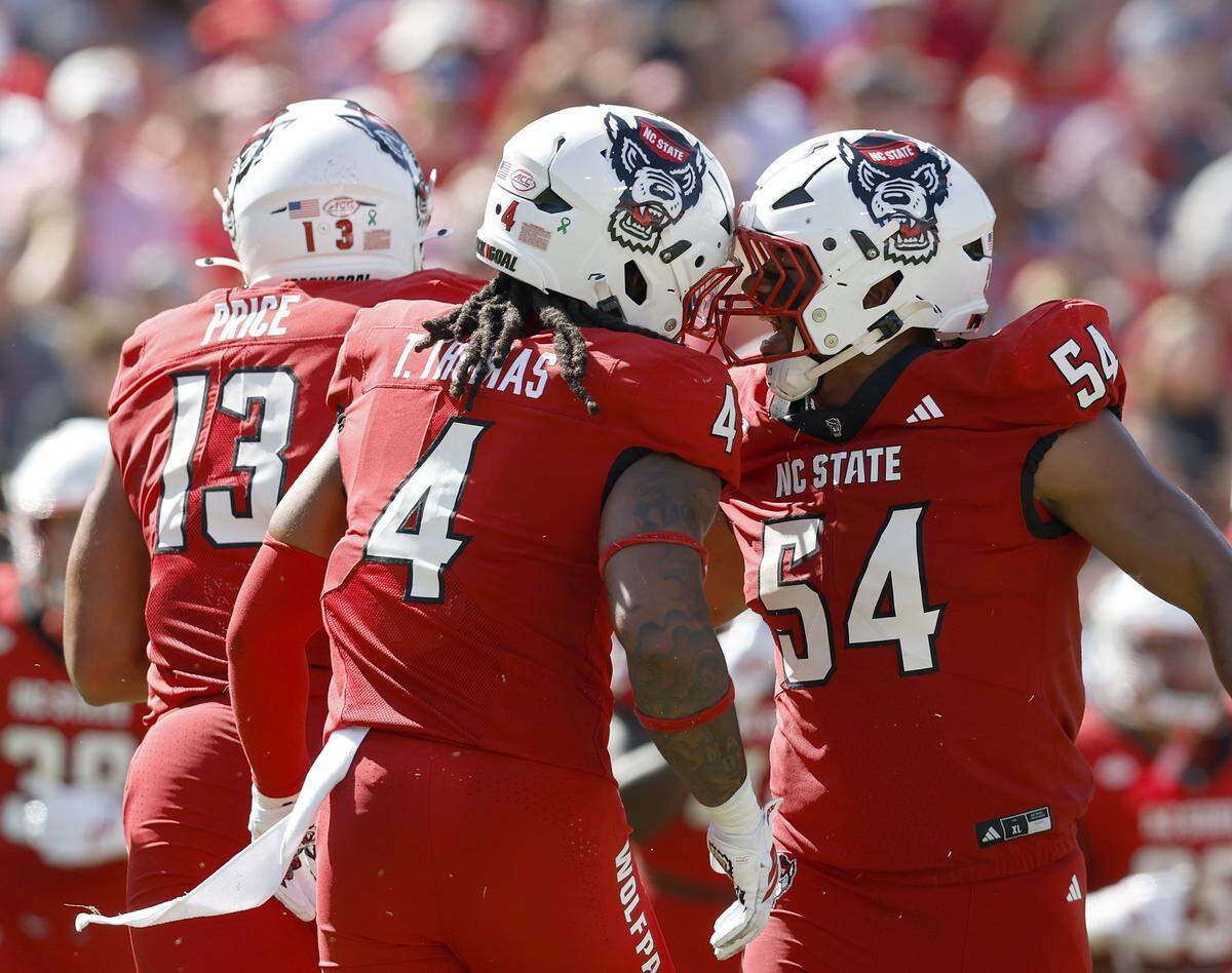 N.C. State’s Tra Thomas and Sabastian Harsh celebrate after a defensive stop during the first half of the Wolfpack’s game against Campbell on Saturday, Oct. 4, 2025, at Carter-Finley Stadium in Raleigh, N.C.