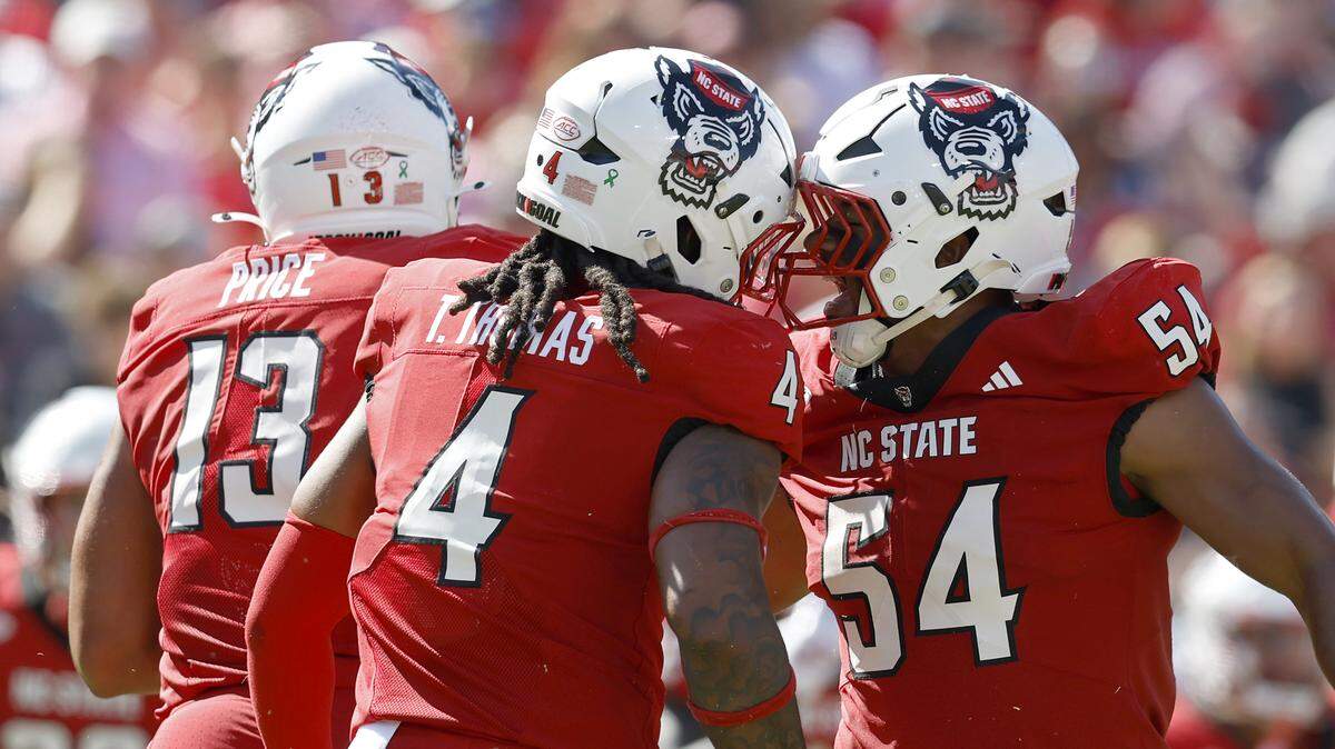N.C. State’s Tra Thomas and Sabastian Harsh celebrate after a defensive stop during the first half of the Wolfpack’s game against Campbell on Saturday, Oct. 4, 2025, at Carter-Finley Stadium in Raleigh, N.C.