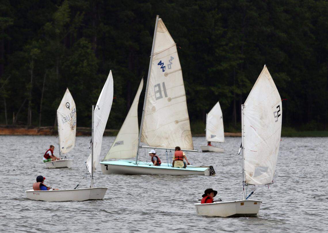 Two summer sailing camp students in a larger 420 class sail craft seem surrounded by single sail Optimist dinghies during Tuesday, July 14, 2015’s sailing camp at Crosswinds Boating Center at Jordan Lake. The yearly summer sailing camp, held for about 15 years on triangle area lakes, the past two years at Jordan Lake is run by the Carolina Sailing Foundation. The weeklong (Monday-Friday) day sailing camps are for students 9-16 years old. The yearly summer camp started in mid-June and runs through early August this year. The campers learn on the single seat Optimist dinghys, and on the larger two-person 420 class sailboats.