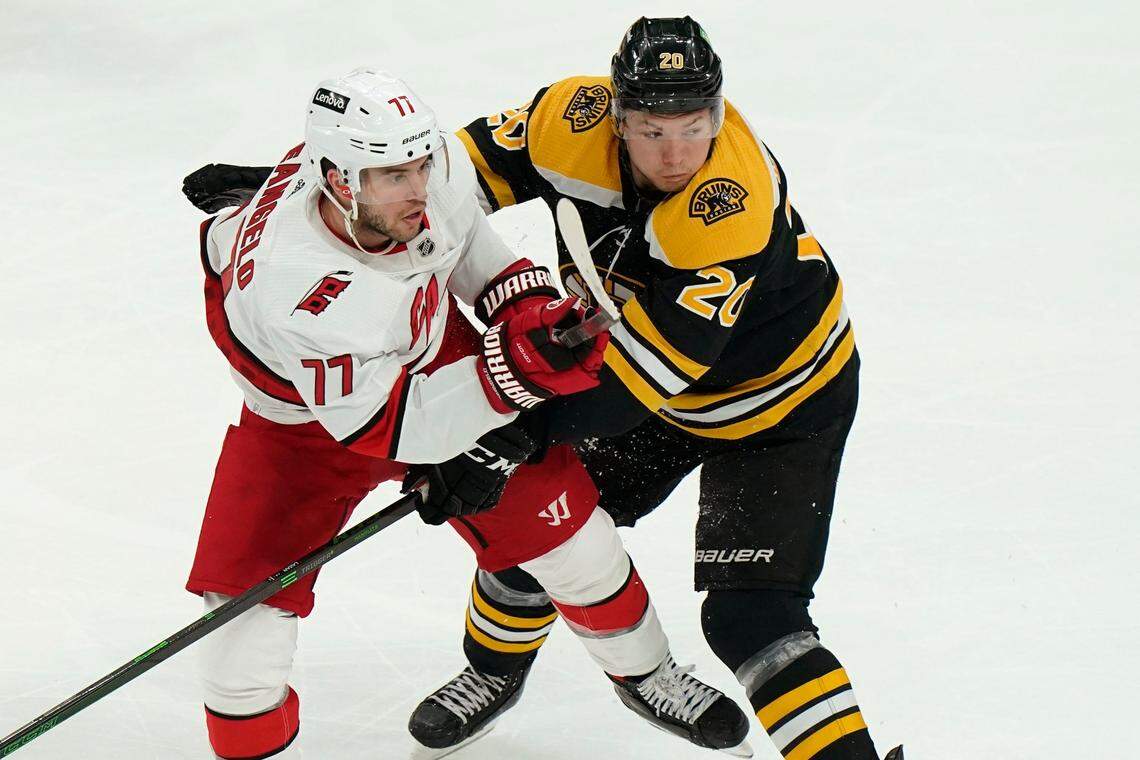 Carolina Hurricanes’ Tony DeAngelo (77) and Boston Bruins’ Curtis Lazar (20) tangle in the second period of Game 4 of an NHL hockey Stanley Cup first-round playoff series, Sunday, May 8, 2022, in Boston. The Bruins won 5-2. (AP Photo/Steven Senne)