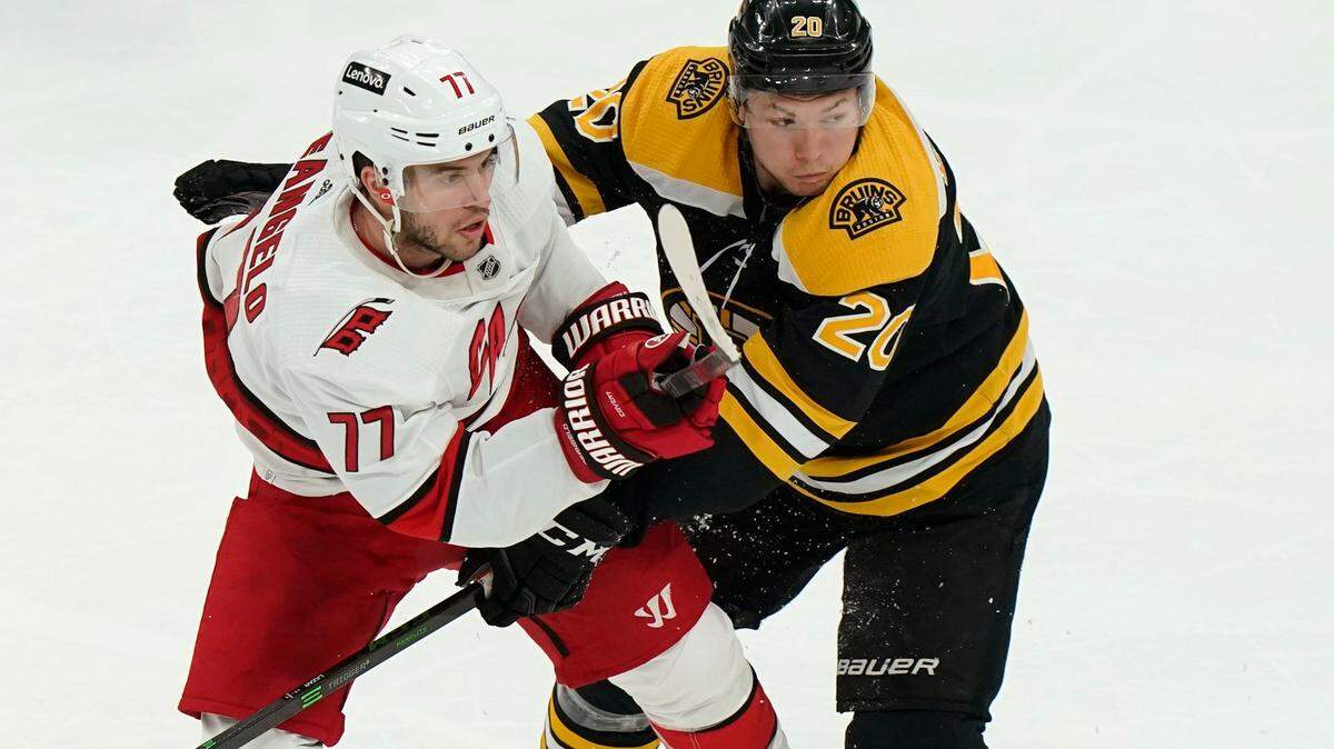 Carolina Hurricanes’ Tony DeAngelo (77) and Boston Bruins’ Curtis Lazar (20) tangle in the second period of Game 4 of an NHL hockey Stanley Cup first-round playoff series, Sunday, May 8, 2022, in Boston. The Bruins won 5-2. (AP Photo/Steven Senne)