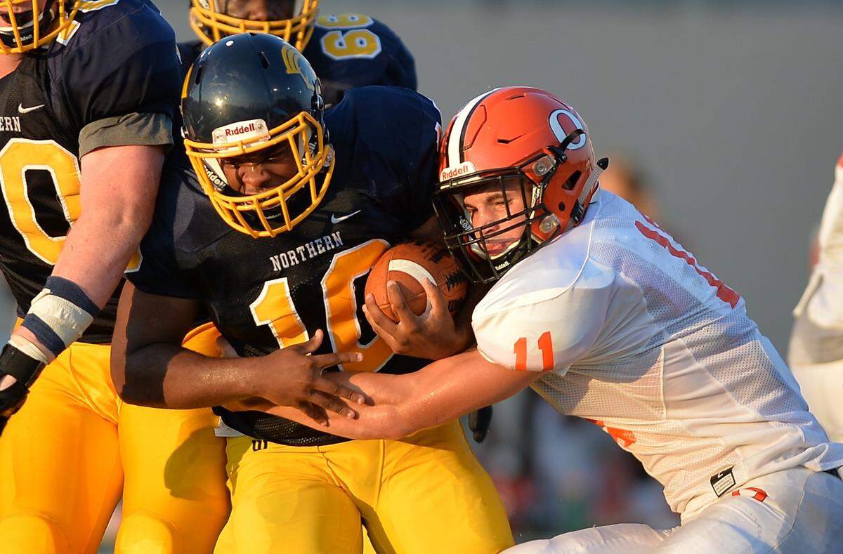Orange High School’s Payton Wilson tackles Northern’s De’shi Atkins, during a game in August 2016.