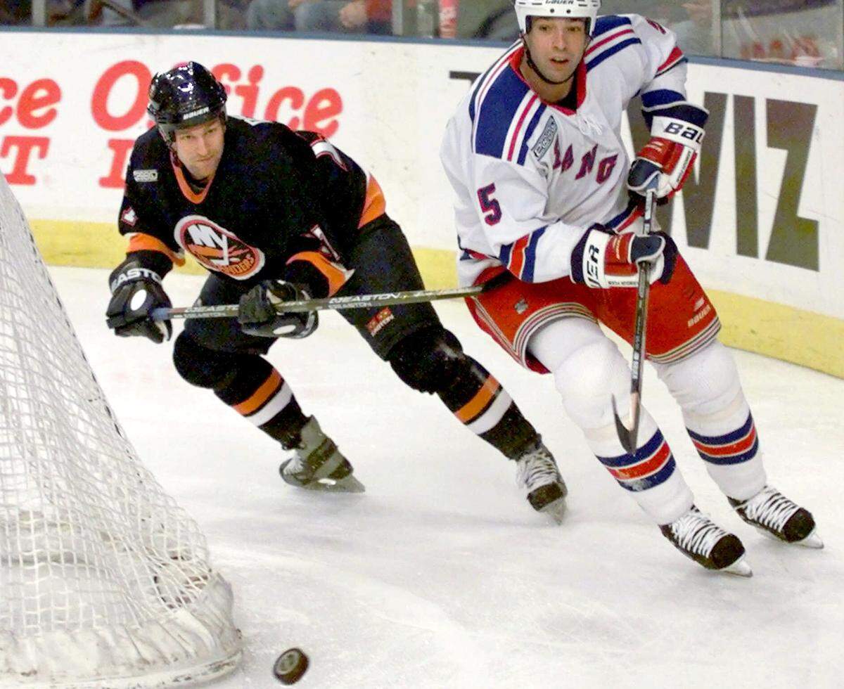 New York Islanders' Ted Drury, left, uses his stick on Stephane Quintal (5) of the New York Rangers as they go after a loose puck during the first period on Nov. 3, 1999, at Madison Square Garden in New York.
