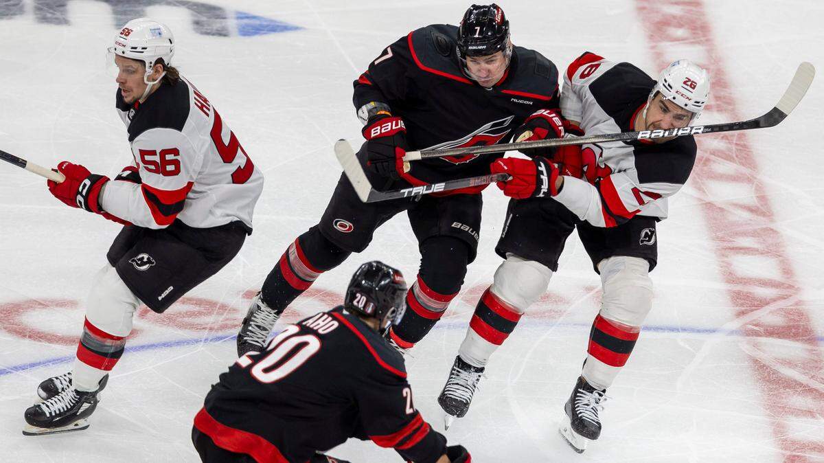 New Jersey right wing Timo Meier (28) takes a stick to the face from Carolina Hurricanes defenseman Dmitry Orlov (7) in the second period on Sunday, April 20, 2025 at Lenovo Center in Raleigh, N.C.