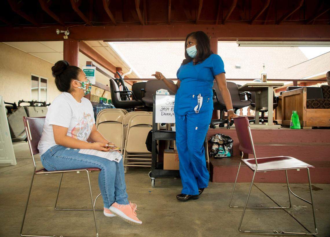 Farmworker Andrea Ortiz, left, talks with Teresa Hurtt after receiving her COVID-19 vaccine at the Episcopal Farmworker Ministry, on Saturday, Apr. 10, 2021, in Dunn, N.C.