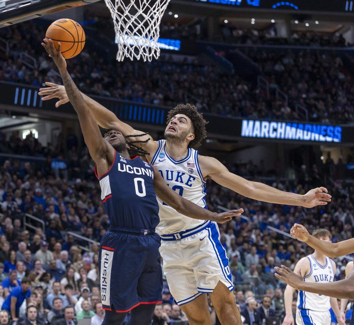 Connecticut guard Malachi Smith (0) breaks to the basket against Duke forward Cameron Boozer (12) in the second half on Sunday, March 29, 2026, in the NCAA East Regional Championship, at Capital One Arena in Washington, D.C.