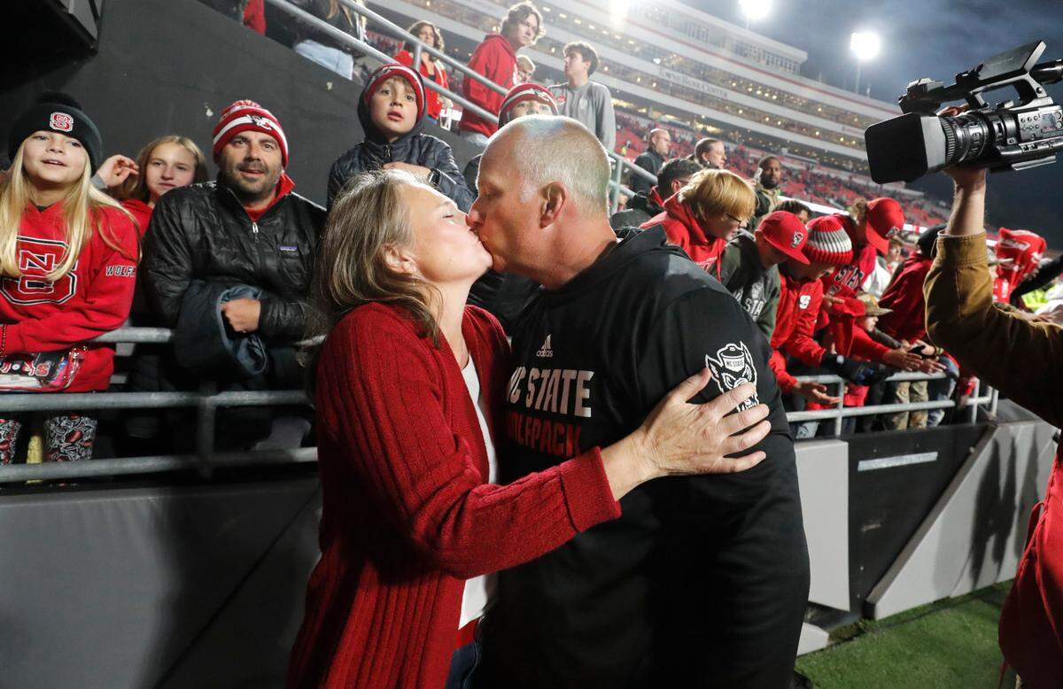 N.C. State head coach Dave Doeren kisses his wife Sara after the Wolfpack’s 20-6 victory over Miami at Carter-Finley Stadium in Raleigh, N.C., Saturday, Nov. 4, 2023.