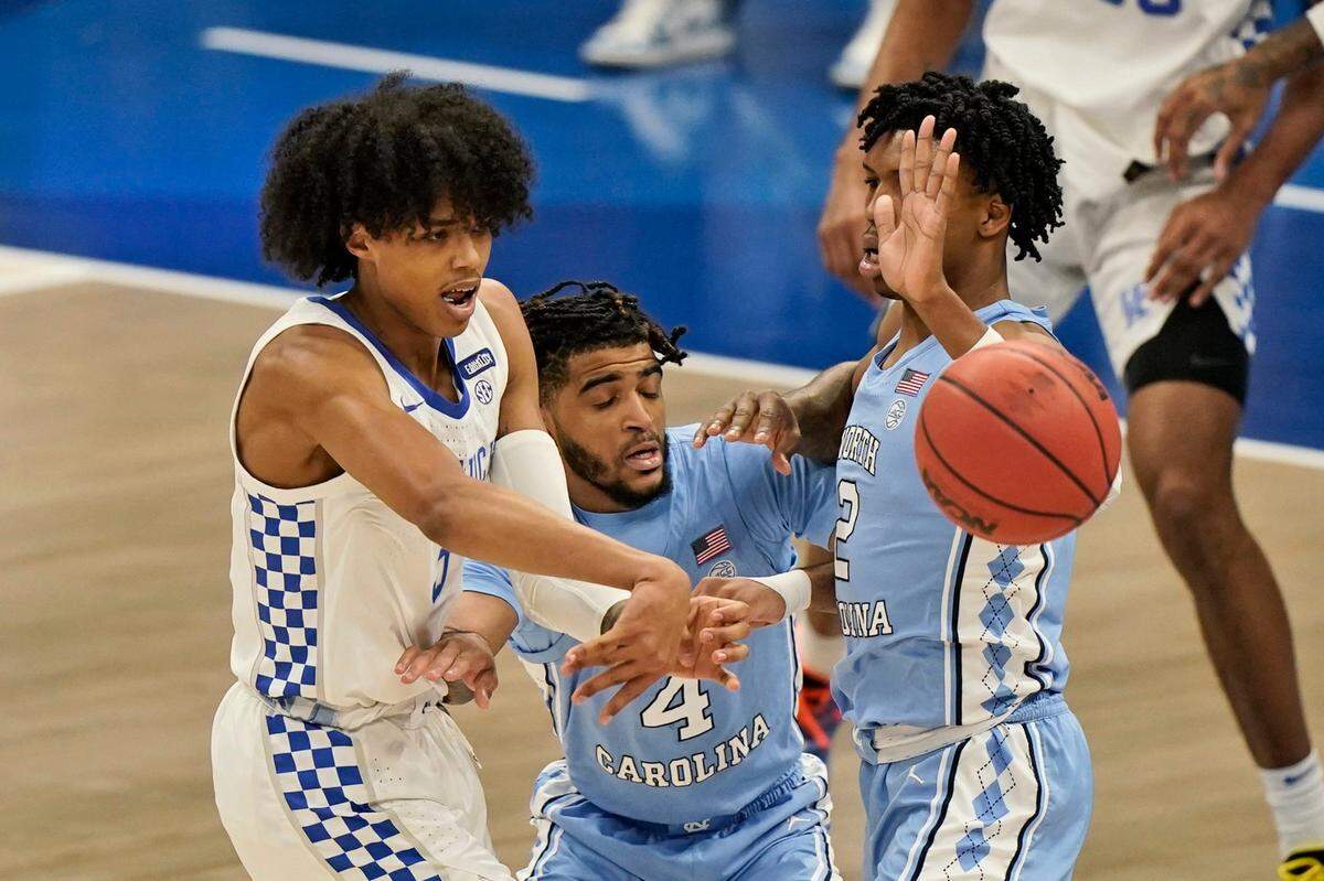 Kentucky’s Brandon Boston Jr., left, passes against North Carolina in the first half of an NCAA college basketball game, Saturday, Dec. 19, 2020, in Cleveland.