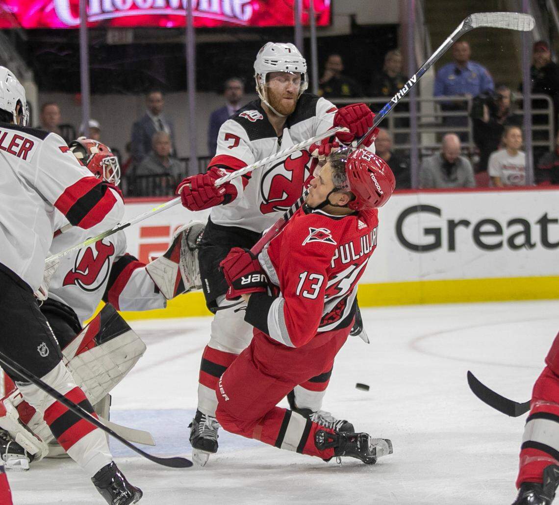 The New Jersey Devils Dougie Hamilton (7) checks the Carolina Hurricanes Jesse Piljujarvi (13) to the ice in the in the first period during Game 1 of their second round Stanley Cup playoff series on Wednesday, May 3, 2023 at PNC Arena in Raleigh, N.C.