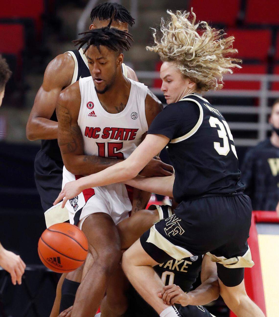 N.C. State’s Manny Bates (15) and Wake Forest’s Carter Whitt (35) go for the ball during the first half of N.C. State’s game against Wake Forest at PNC Arena in Raleigh, N.C., Wednesday, January 27, 2021.