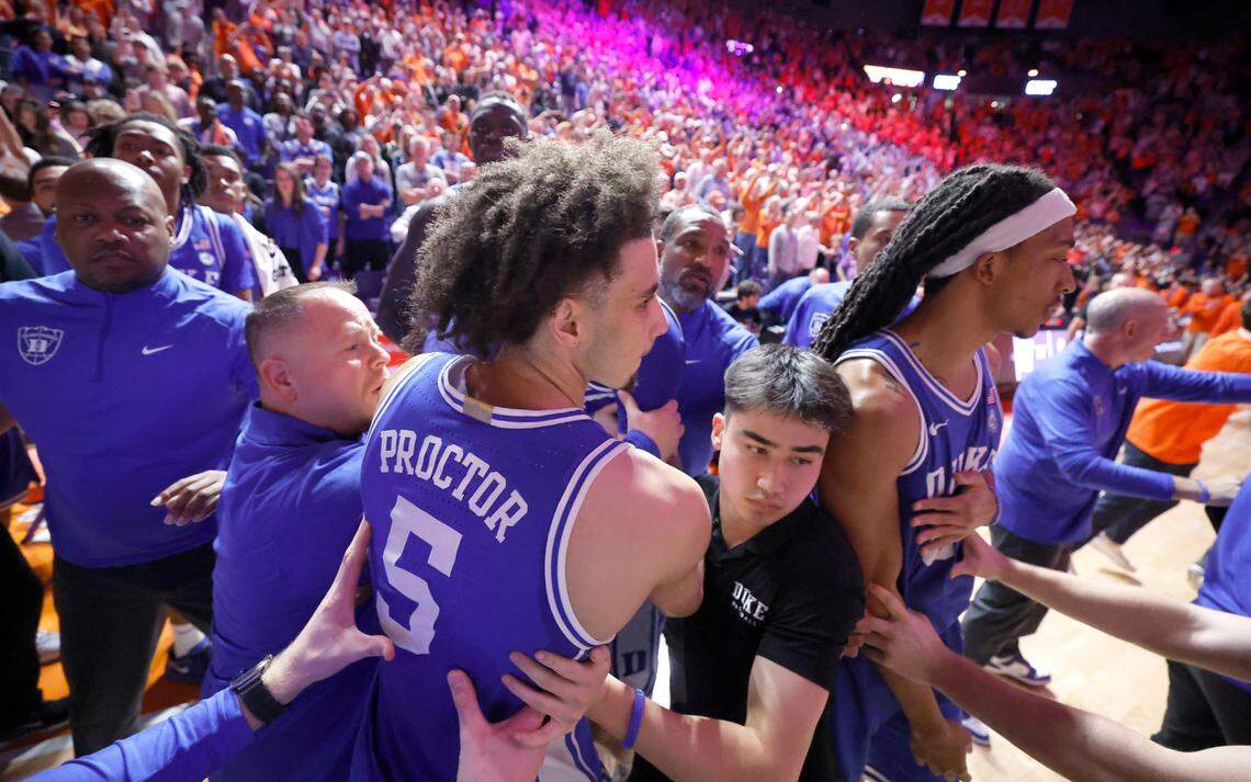Fans storm the court as Duke staff try to keep them from the players after Clemson’s 77-71 victory over Duke at Littlejohn Coliseum in Clemson, S.C., Saturday, Feb. 8, 2025.