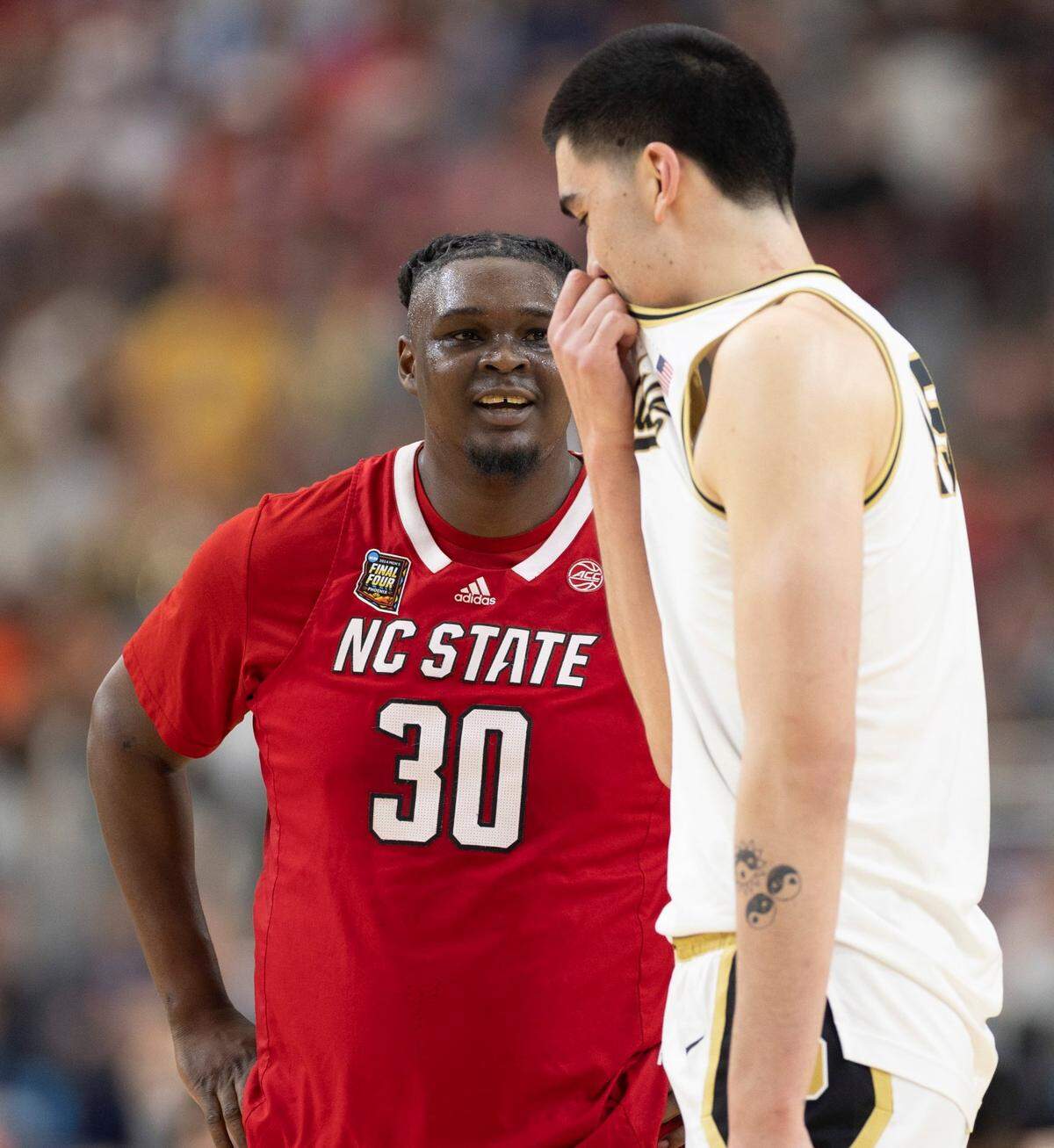 N.C. State’s D.J. Burns Jr. (30) has a conversation with Purdue’s Zach Edey (15) as they wait for play to resume during the first half in the NCAA Final Four National Semifinal game on Saturday, April 6, 2024 at State Farm Stadium in Glendale, AZ.