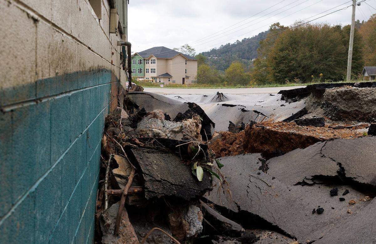 The asphalt buckles and slopes outside of Bald Guy Brew following damage from Hurricane Helene on Monday, Sept. 30, 2024, in Boone, N.C.