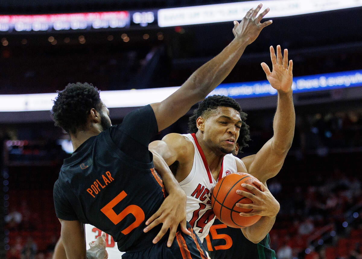 N.C. State’s Casey Morsell drives between Miami’s Wooga Poplar and Norchad Omier during the first half of the Wolfpack’s game on Tuesday, Jan. 30, 2024, at PNC Arena in Raleigh, N.C.