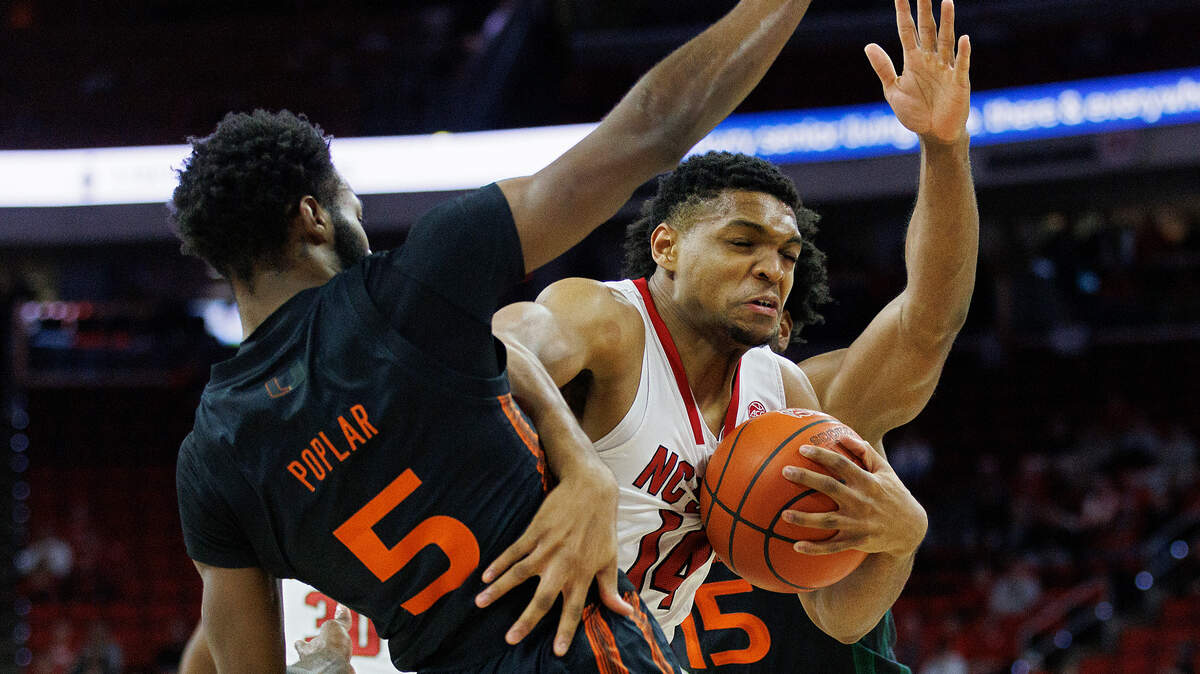 N.C. State’s Casey Morsell drives between Miami’s Wooga Poplar and Norchad Omier during the first half of the Wolfpack’s game on Tuesday, Jan. 30, 2024, at PNC Arena in Raleigh, N.C.
