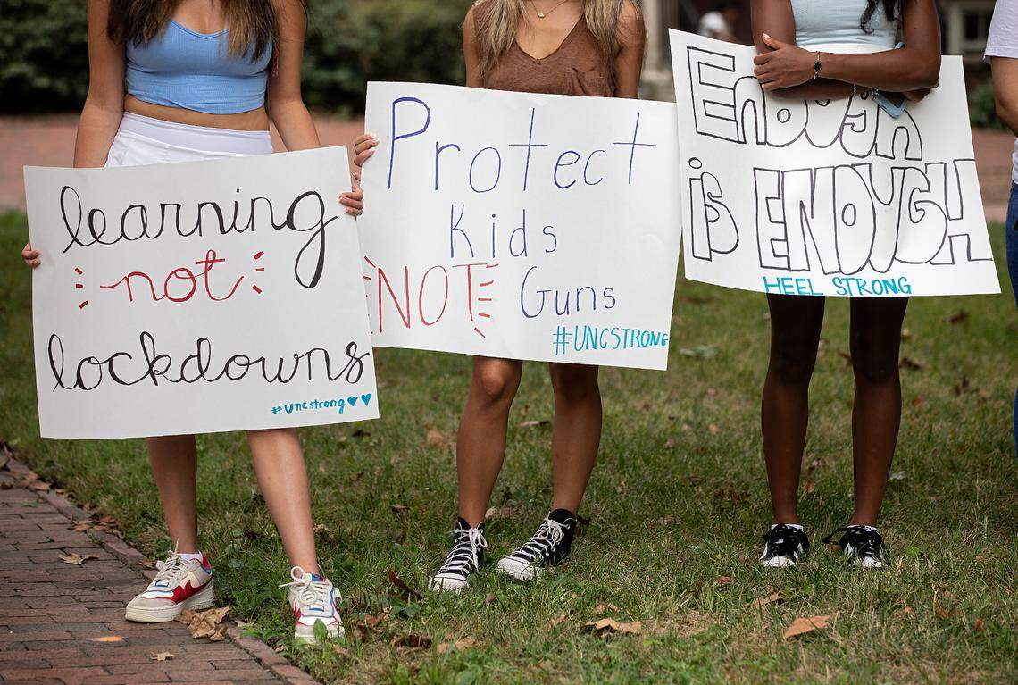 People hold signs during a student-led rally at UNC-Chapel Hill in support of gun control on Wednesday, Aug. 30, 2023. A graduate student has been charged with first-degree murder following a Monday shooting that left a faculty member dead on the campus.