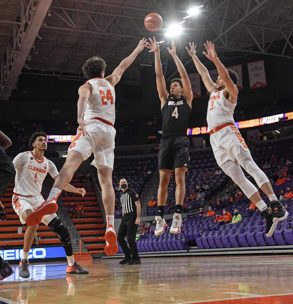 NC State forward Jericole Hellems(4) shoots between Clemson freshman forward PJ Hall (24) and Clemson sophomore guard Chase Hunter(3) during the first half of their game on Jan. 5, 2021.