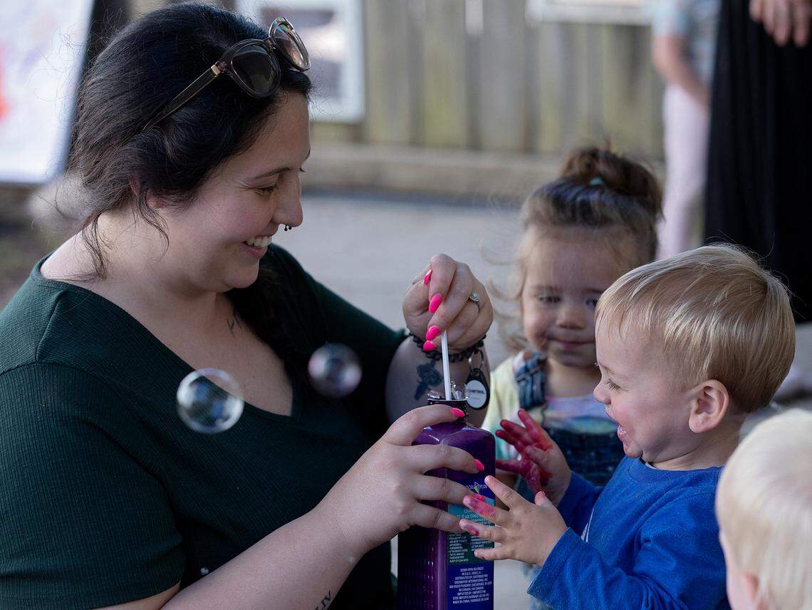 Haley Durham, a teacher at the Little School of Hillsborough, prepares to blow bubbles to the delight of Wells, 1, on Thursday, April 18, 2024, in Hillsborough, N.C.