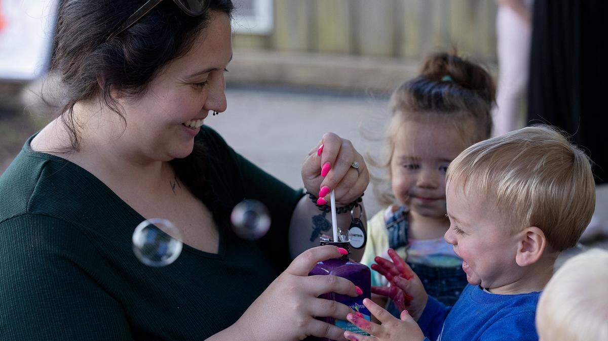 Haley Durham, a teacher at the Little School of Hillsborough, prepares to blow bubbles to the delight of Wells, 1, on Thursday, April 18, 2024, in Hillsborough, N.C.