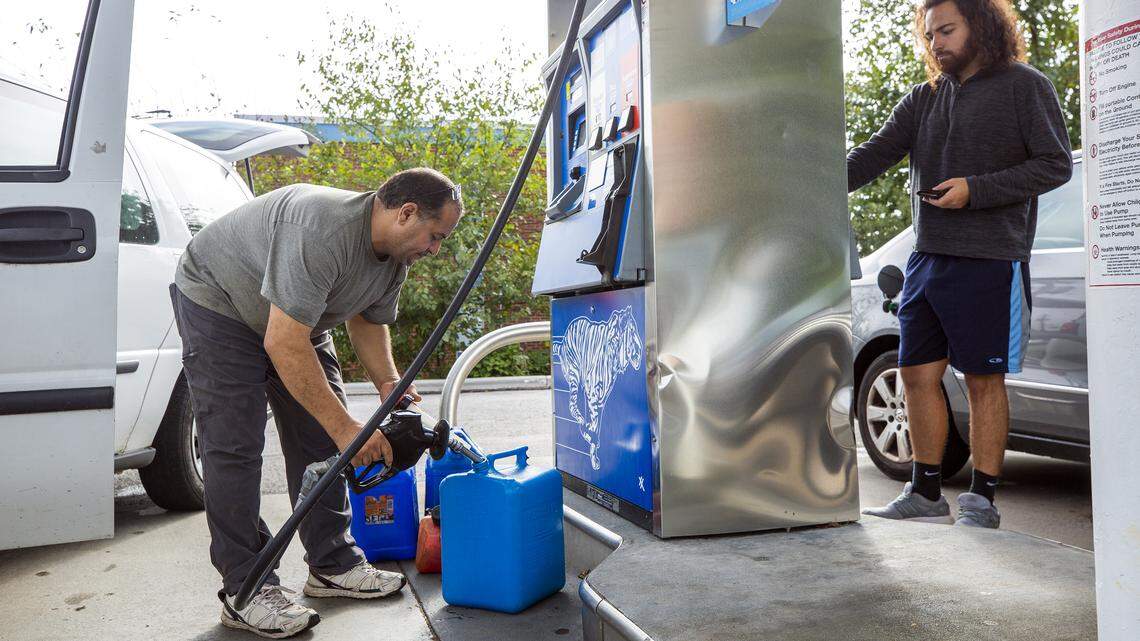 Tarek Elshik, left, fills gas cans to fuel a generator to refrigerate insulin for his 10-year-old daughter, Yasmeen Elshik’s Type 1 diabetes treatment in case power goes out during Hurricane Florence. He’s at the Exxon station on Western Boulevard in Raleigh, NC.