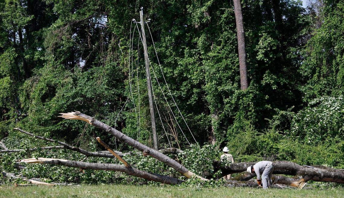 Workers repair a downed power line on Old Stage Road in Raleigh near Garner Friday morning, May 20, 2022.