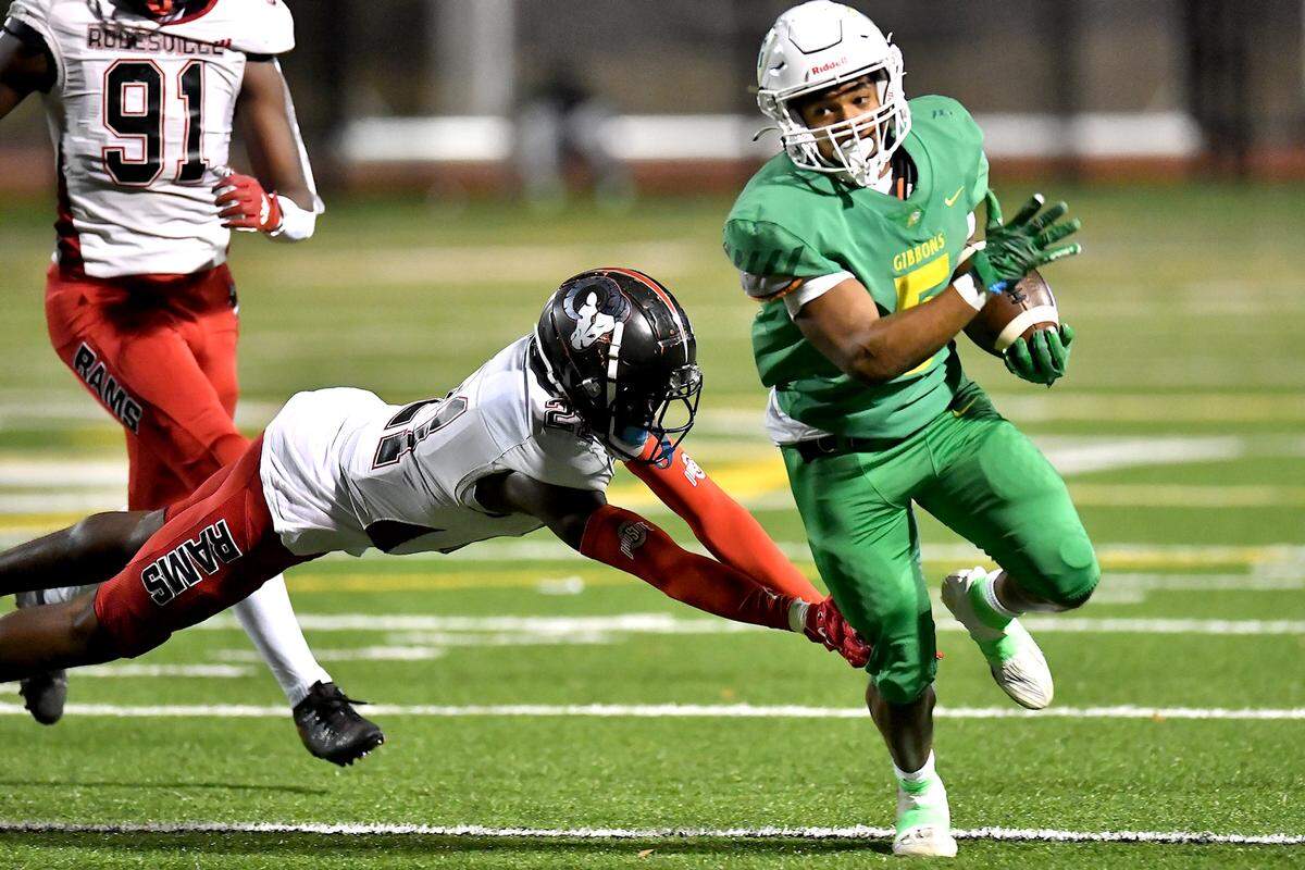 Cardinal Gibbons running back Kendall Scotton (5) runs for the first down against Rolesville’s Cannon Marshall (21) during the first half. The Rolesville Rams and the Cardinal Gibbons Crusaders met in the East Regional Final of the NCHSAA 4A football playoffs in Raleigh, N.C. on December 13, 2024.