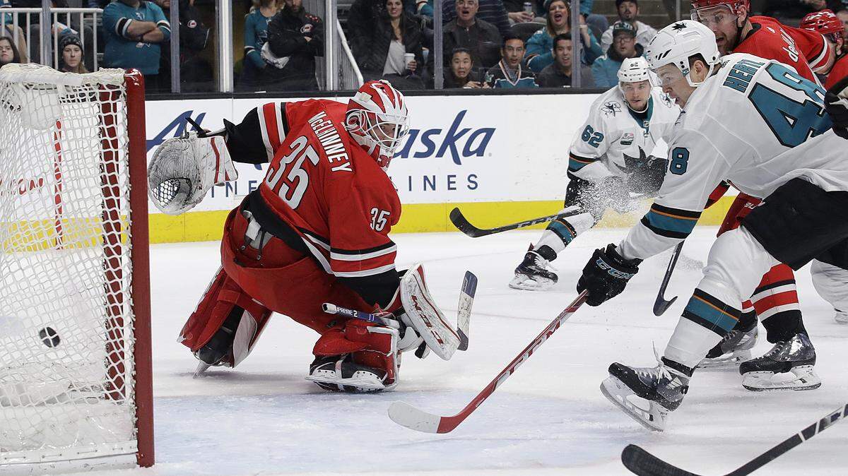 San Jose Sharks center Tomas Hertl, from the Czech Republic, right, scores a goal past Carolina Hurricanes goaltender Curtis McElhinney (35) during the first period of an NHL hockey game in San Jose, Calif., Wednesday, Dec. 5, 2018. (AP Photo/Jeff Chiu)