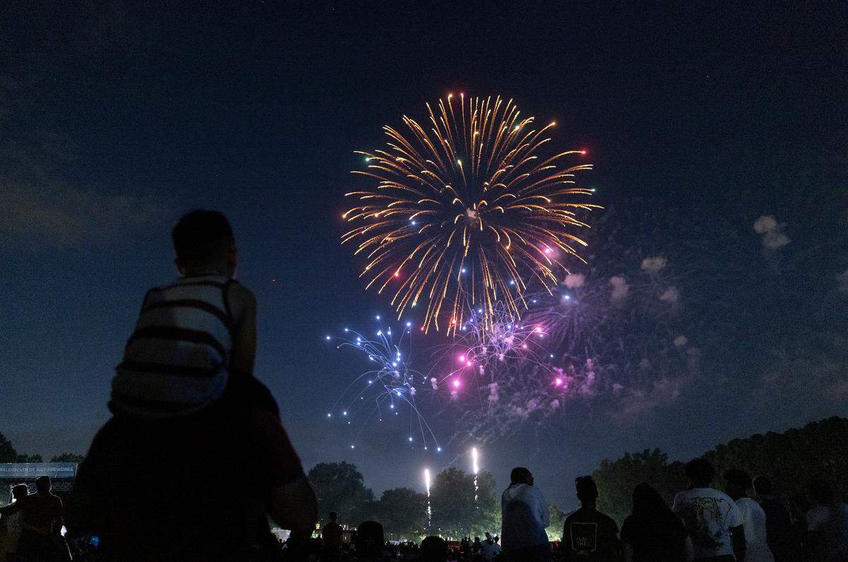 Crowds watch a fireworks display during an Independence Day celebration at Dorothea Dix Park on Tuesday, July 4, 2023, in Raleigh, N.C.