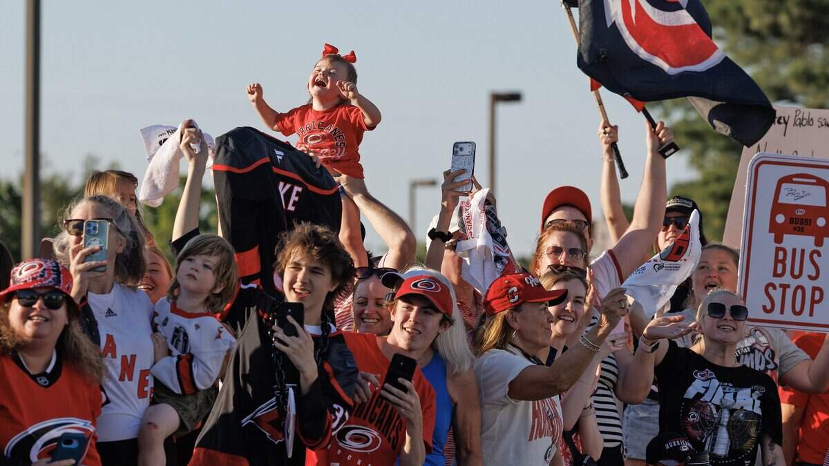 Fans cheer as the Carolina Hurricanes depart Raleigh-Durham International Airport on Monday, June 15, after the team defeated the Vegas Golden Knights to win the Stanley Cup.