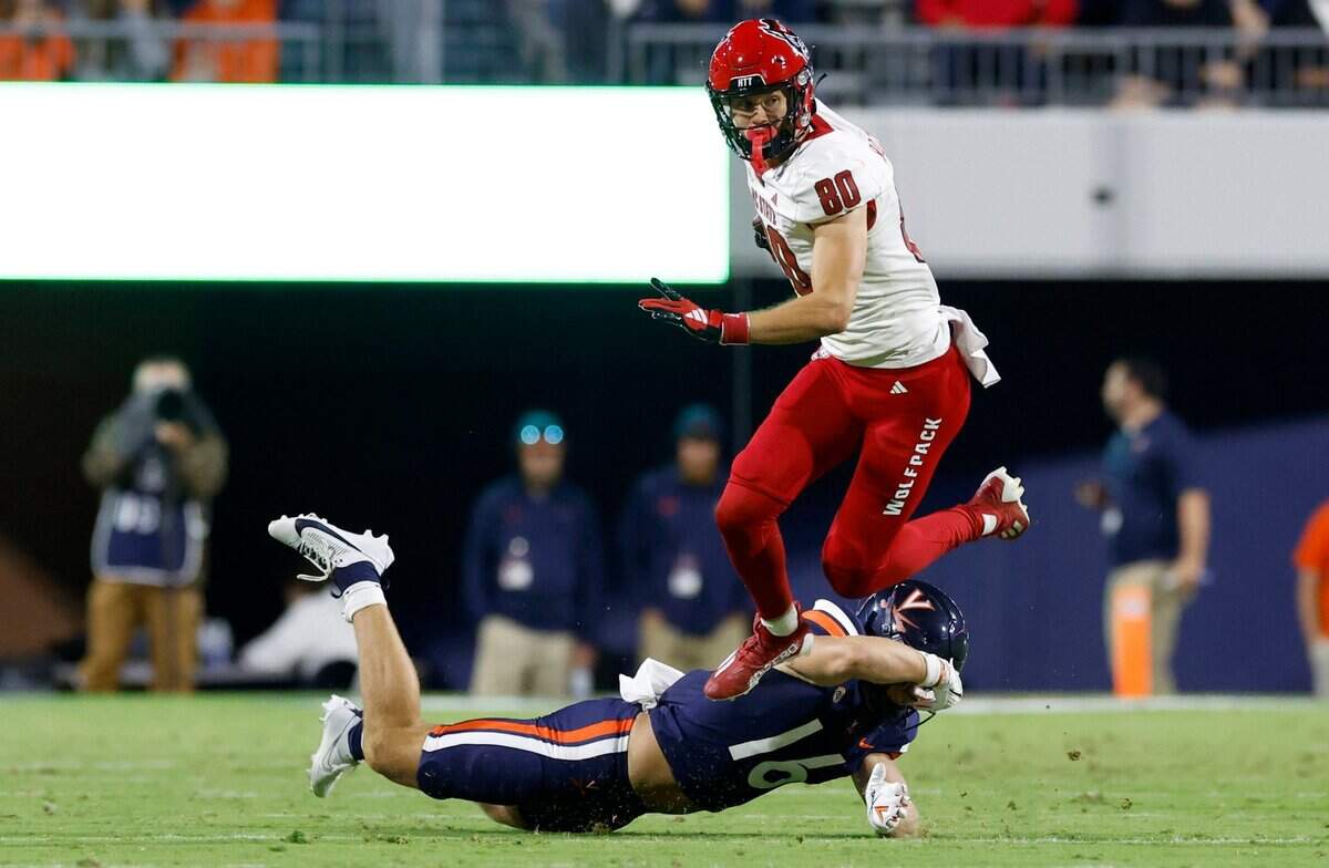 N.C. State wide receiver Bradley Rozner (80) jumps over the tackle by Virginia linebacker Trey McDonald (16) during the first half of N.C. State’s game against Virginia at Scott Stadium in Charlottesville, Va., Friday, Sept. 22, 2023.