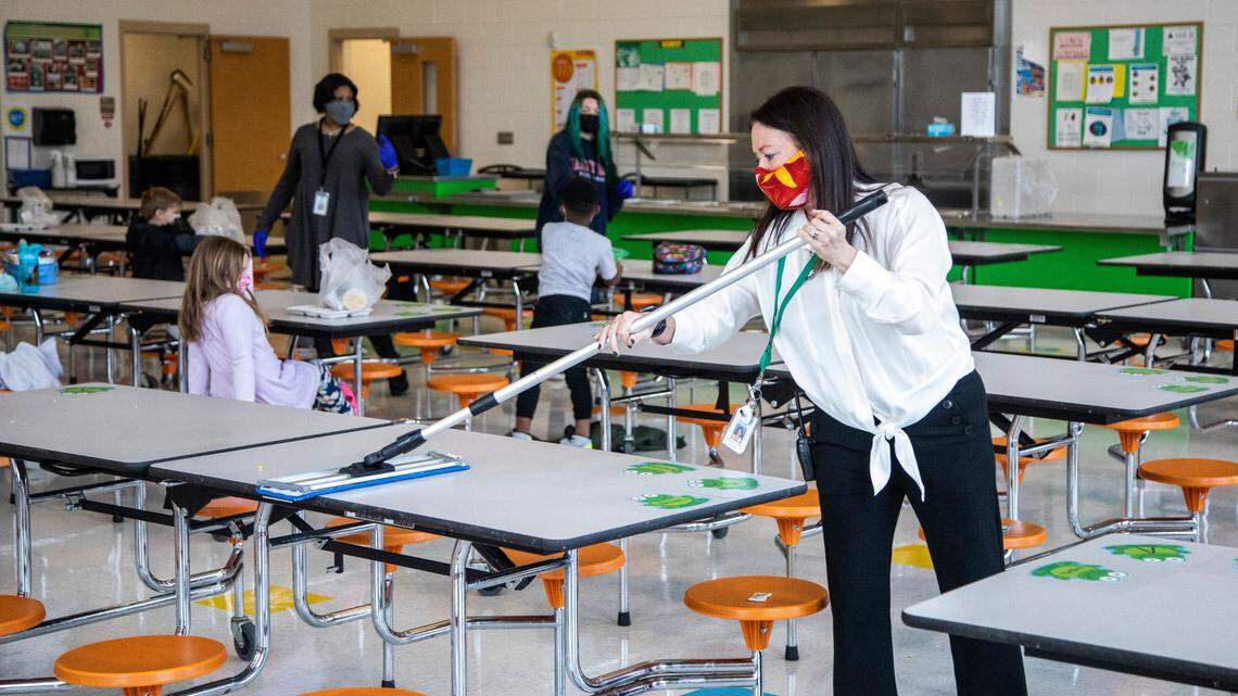Lisa Brown, principal of Green Elementary School, sanitizes cafeteria tables, March 15, 2021 at the Raleigh school.