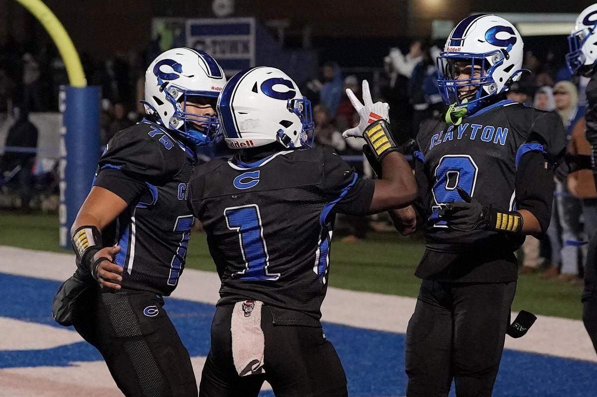 Clayton running back Noah Smith (1) celebrates his touchdown run against Southeast Raleigh with Cory Robinson (75) and DeAngelo Ruffin (9) during the first half. The Clayton Comets and the Southeast Raleigh Bulldogs met in the fourth round of the NCHSAA 7A Playoffs in Clayton, N.C. on November 28, 2025.