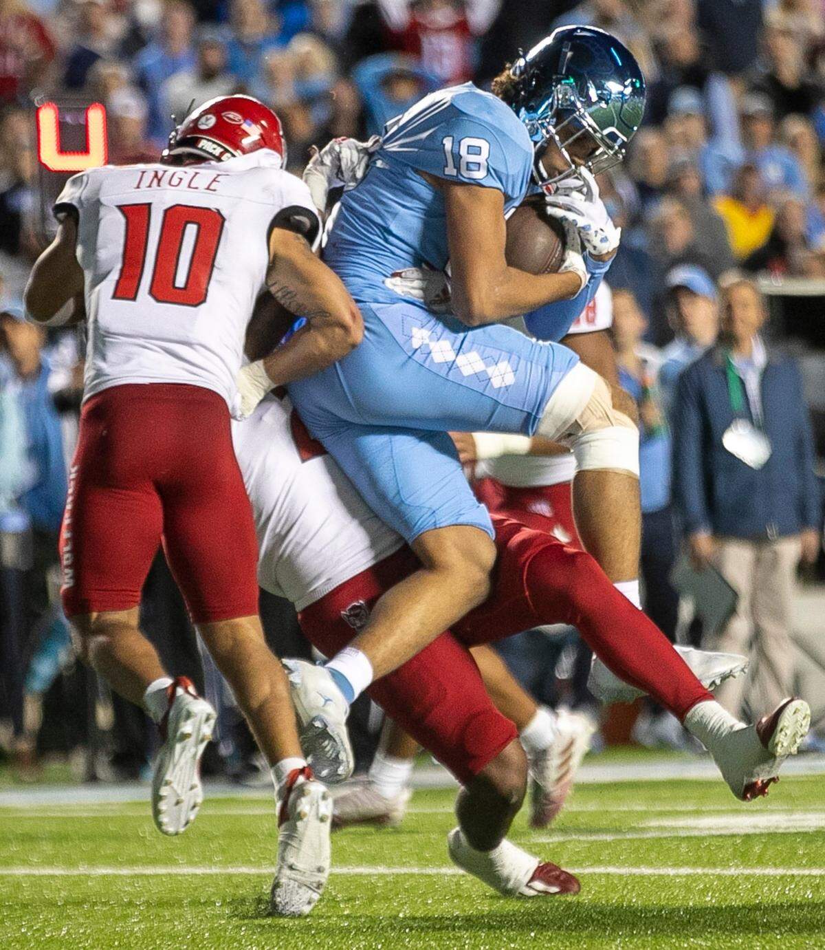 North Carolina receiver Bryson Nesbitt (18) pulls in a nine-yard pass from quarterback Drake Maye on fourth down to keep the Tar Heels’ final drive alive in the final minute of play against N.C. State on Friday, November 25, 2022 at Kenan Stadium in Chapel Hill, N.C.