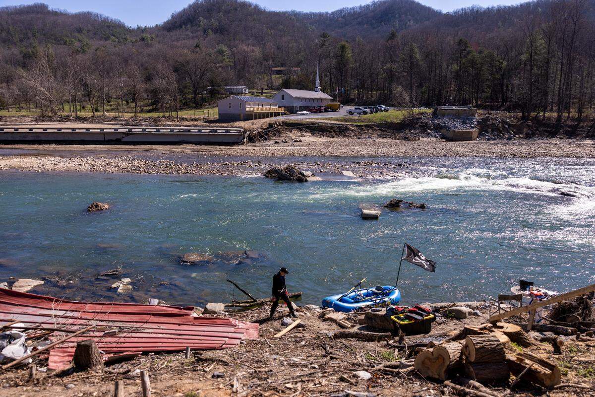 Mike Crooks prepares to ferry Appalachian Trail hikers across the Nolichucky River near where the Chestoa Pike Bridge was destroyed by the remnants of Hurricane Helene in Erwin, Tennessee.