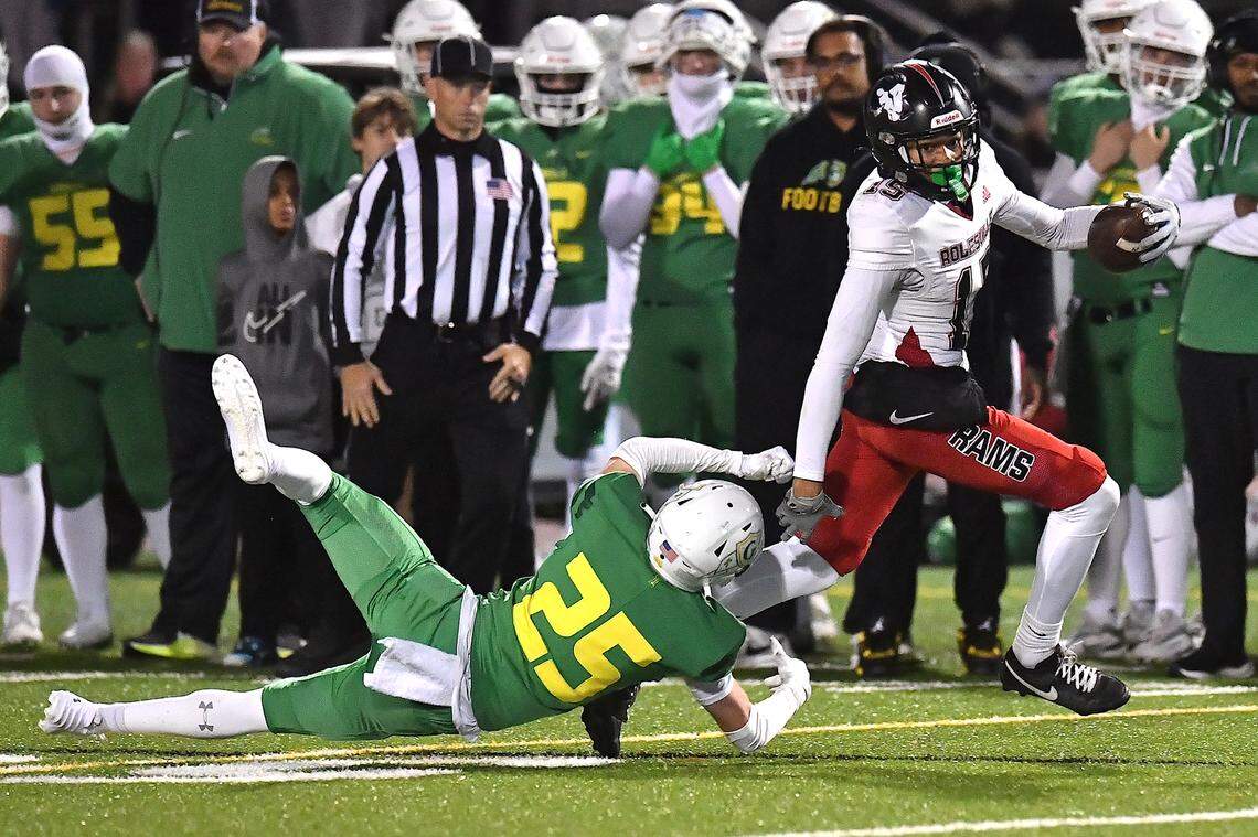 Rolesville’s Davis Brown (15) rushes for yards against Cardinal Gibbons’ Hank Yardley (25) during the second half. The Rolesville Rams and the Cardinal Gibbons Crusaders met in the East Regional Final of the NCHSAA 4A football playoffs in Raleigh, N.C. on December 13, 2024.